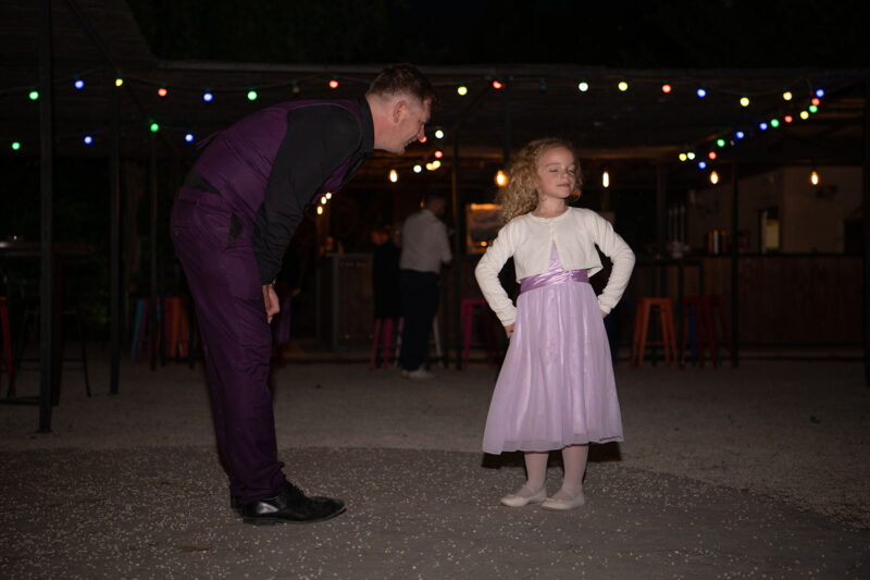 un homme en costume et une petite fille en robe de cérémonie qui semble le snober