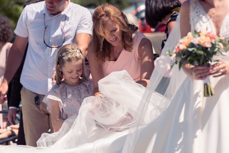 une dame et une petite fille en train de tenir le voile de la mariée