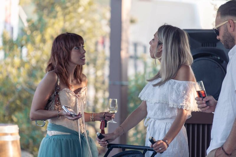 photo de deux jeunes filles en train de discuter un verre à la main