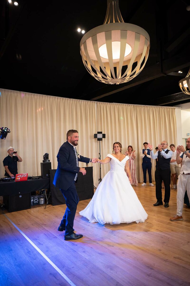 deux mariés en train de danser dans une salle