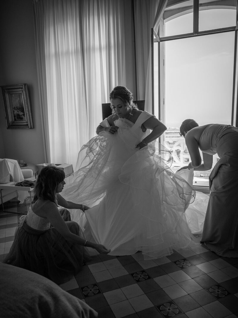 photo noir et blanc d'une mariée en train de mettre sa robe