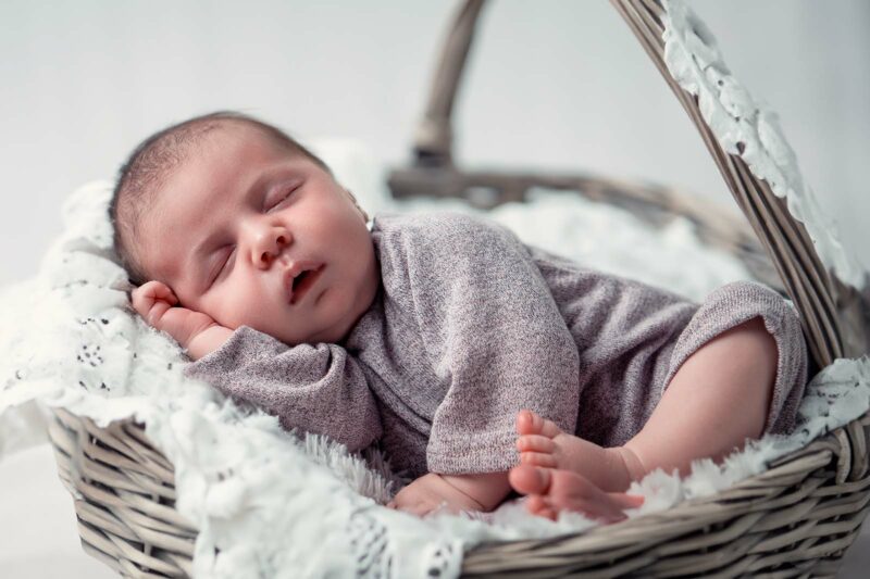 bébé qui dort dans un panier en osier