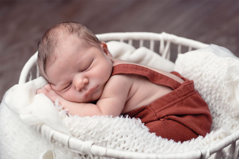 bébé qui dort dans un panier blanc