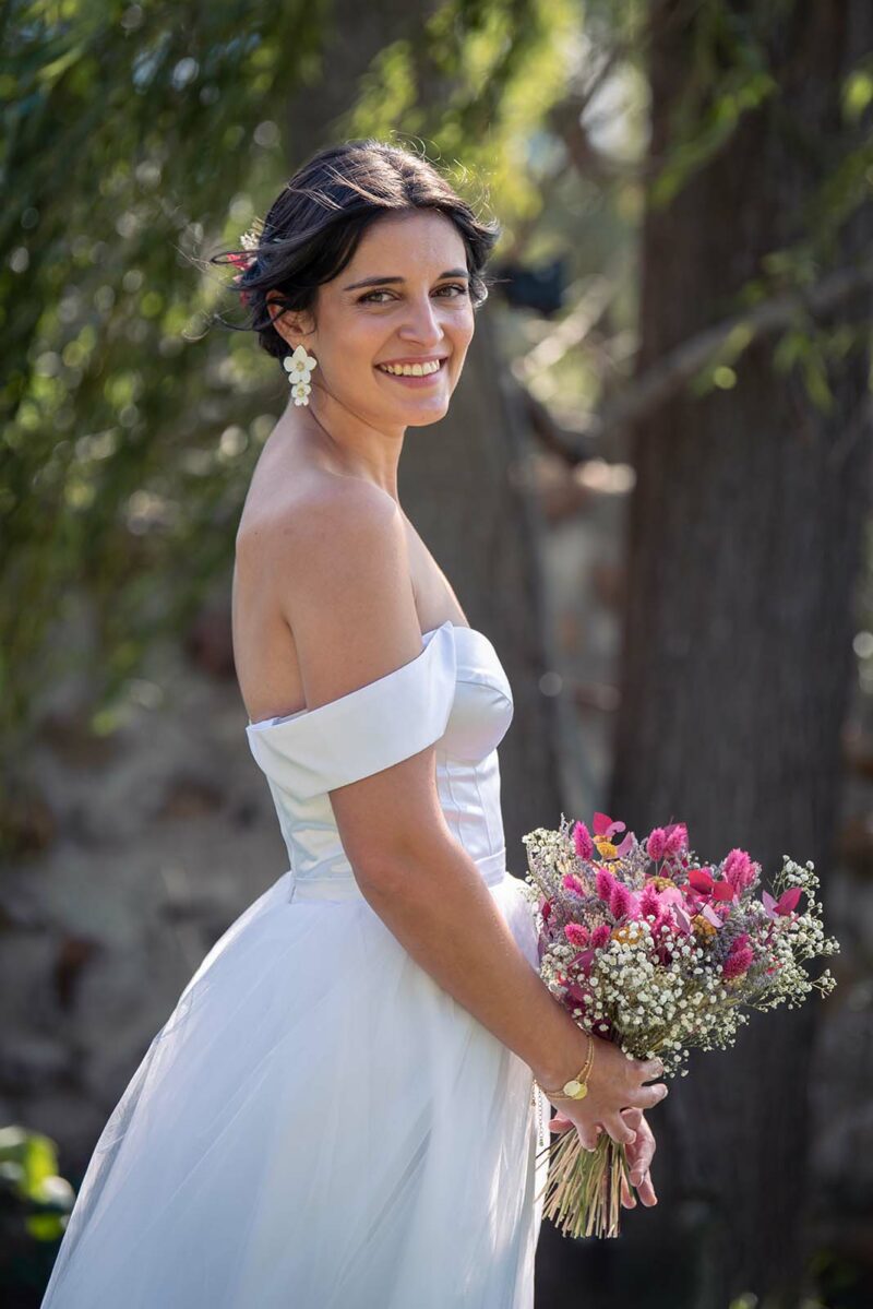 portrait d'une mariée de profil portant son bouquet de fleurs à la main