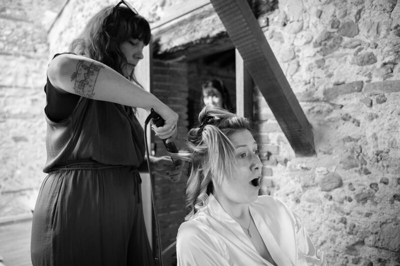 photo noir et blanc d'une femme en train de se faire boucler les cheveux