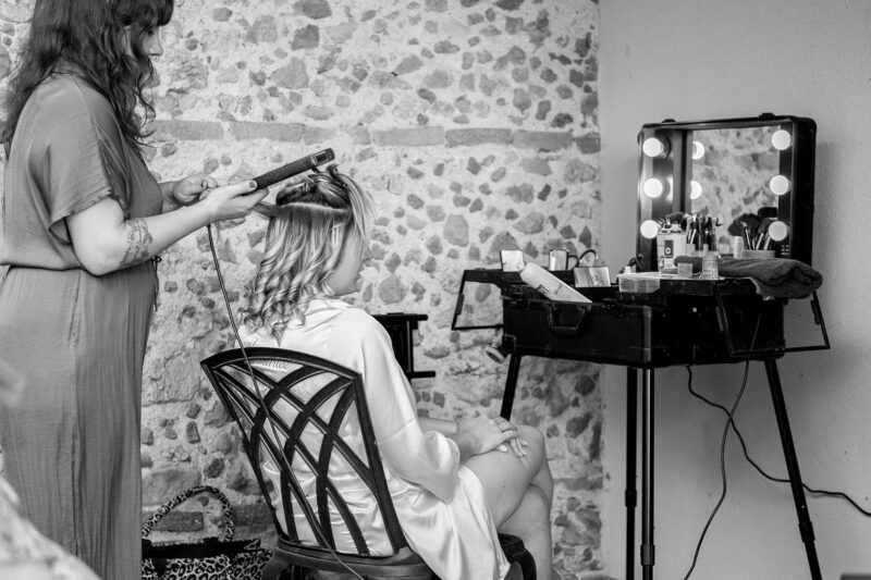 photo noir et blanc d'une femme en train de se faire boucler les cheveux