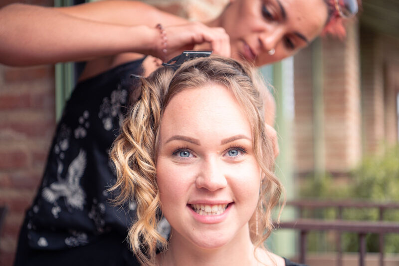 photo d'une jeune femme souriante en train de se faire coiffer
