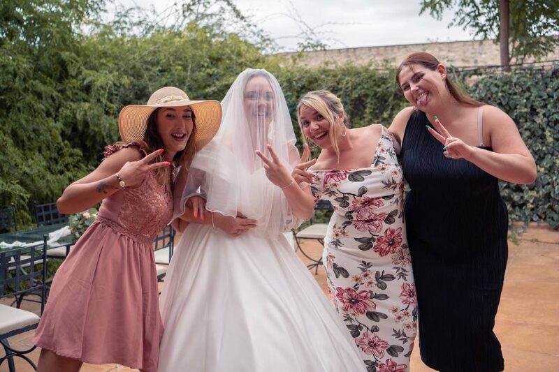 photo d'un groupe de femmes avec une mariée portant son voile sur la tête