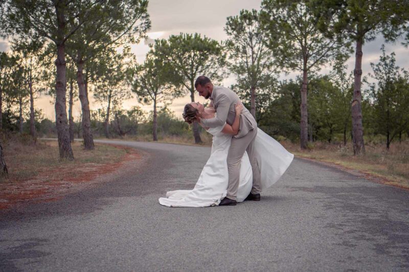 photo d'un couple de mariés dansant dans un chemin au coucher de soleil