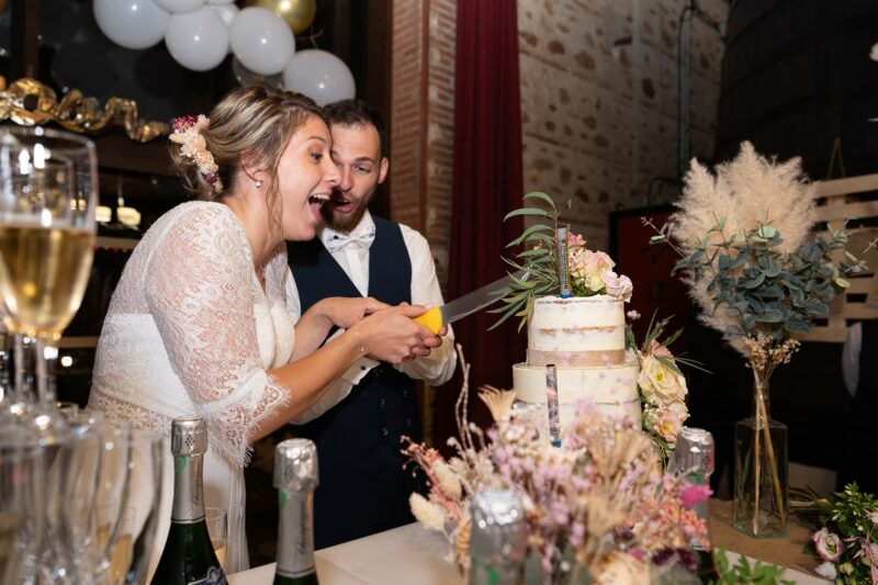 photo de mariés en train de couper leur gâteau