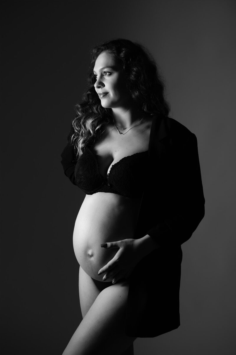 photo noir et blanc d'une femme enceinte vêtue d'une veste de blazer noir