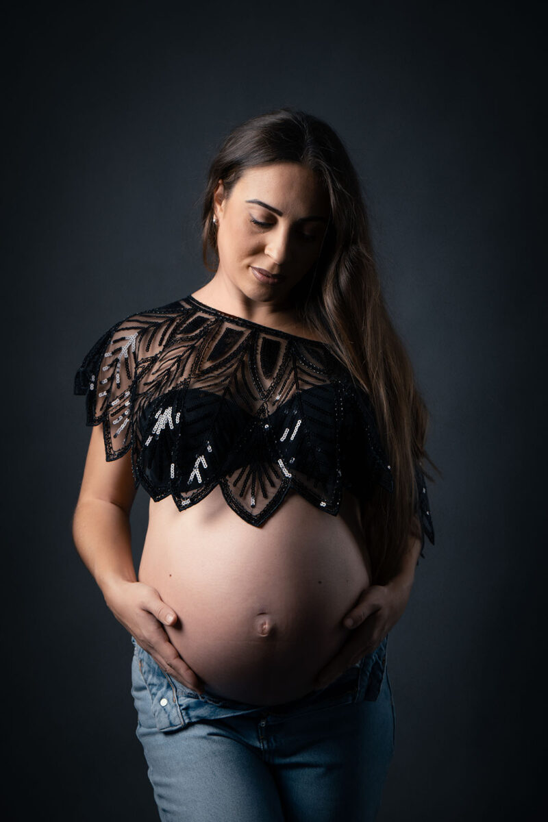 Photo studio d'une femme enceinte portant un crop top noir