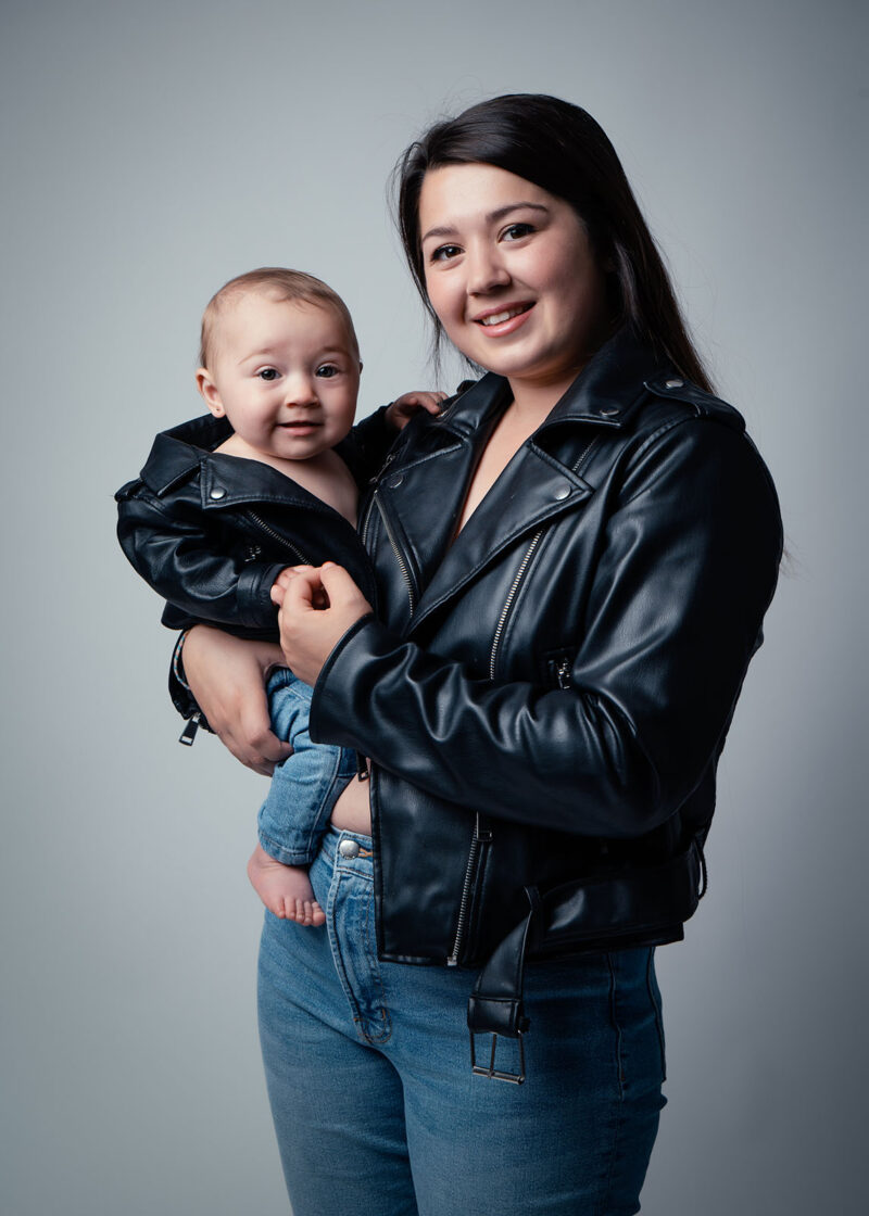 photo studio d'une jeune femme tenant un bébé dans ses bras, les deux sont habillées de manière identique