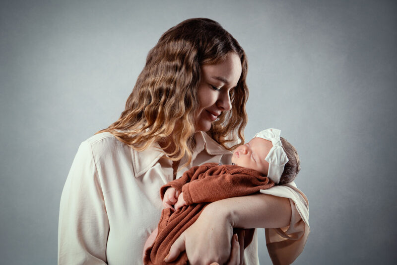 photo studio d'une maman tenant son bébé qui dort dans ses bras