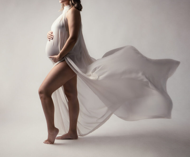 photo studio sur fond blanc d'une robe légère portée par une femme enceinte dont on ne voit pas la tête